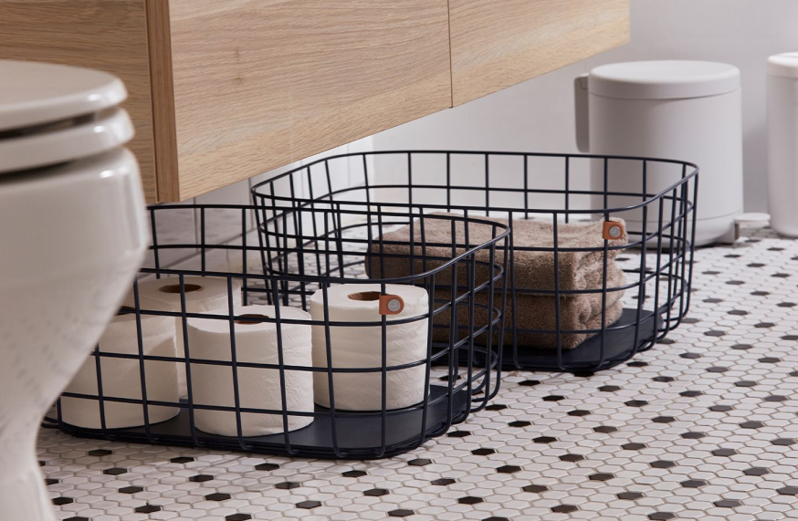 metal storage baskets in the bathroom with towels and toilet paper